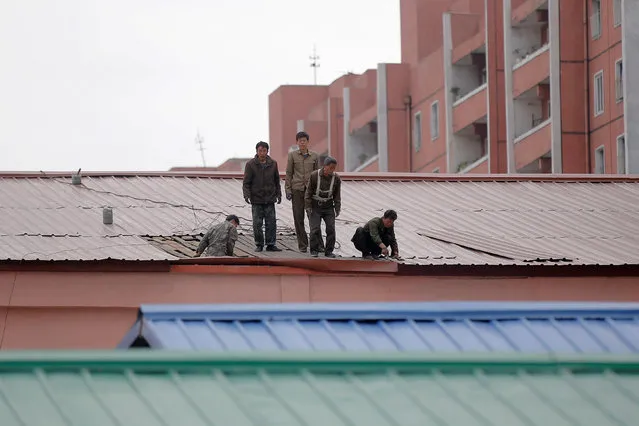 People work on the roof of a building in central Pyongyang, North Korea May 5, 2016. (Photo by Damir Sagolj/Reuters)