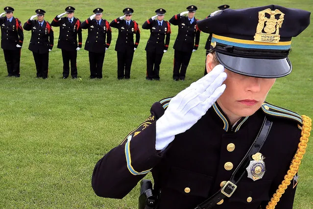 In this photo taken Monday, May 9, 2016, Omaha Police Honor Guard member Leigh Culver joins other officers behind her in saluting the flag as the colors are presented during the 2016 Police Memorial Day Service at the Nebraska Law Enforcement Memorial in Grand Island, Neb. Omaha police officer Kerrie Orozco, who was killed May 20, 2015 as she and other members of the police department tried to arrest a suspect wanted in connection with a September 2014 shooting, had her name added to the memorial wall during the ceremony Monday. Four other officers' names were also unveiled after investigations concluded that they died in the line of duty. (Photo by Barrett Stinson/The Independent via AP Photo)