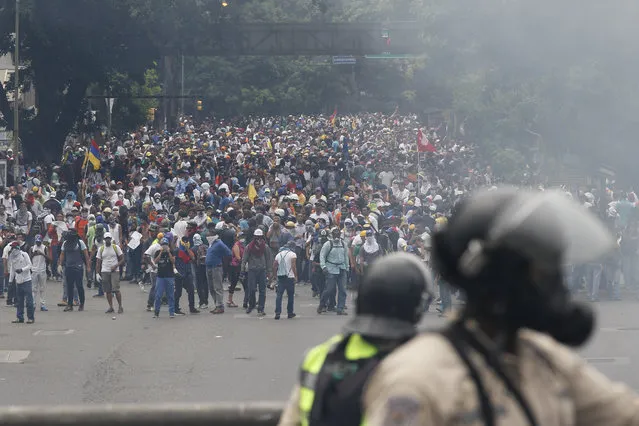 Opponents of President Nicolas Maduro march in Caracas, Venezuela, Thursday, April 20, 2017. Tens of thousands of protesters flooded the streets again Thursday, one day after three people were killed and hundreds arrested in the biggest anti-government demonstrations in years. (Photo by Ariana Cubillos/AP Photo)