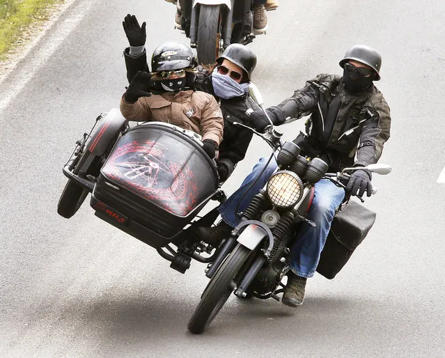 A biker with family members in the side car takes part in a convoy of about thousands of others in Diebach am Haag, Germany, on Sunday, April 23, 2017. The convoy followed a Mass marking the opening of the biker season. (Photo by Michael Probst/AP Photo)