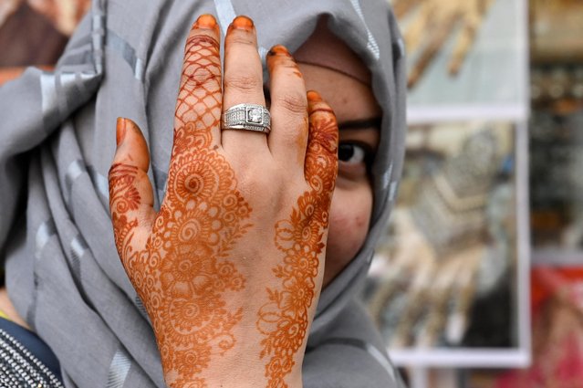 A muslim woman shows her hand painted with henna during Eid al-Fitr, marking the end of the holy month of Ramadan in the suburb of Lakemba in Sydney, Australia on April 21, 2023. (Photo by /Jaimi Joy/Reuters)