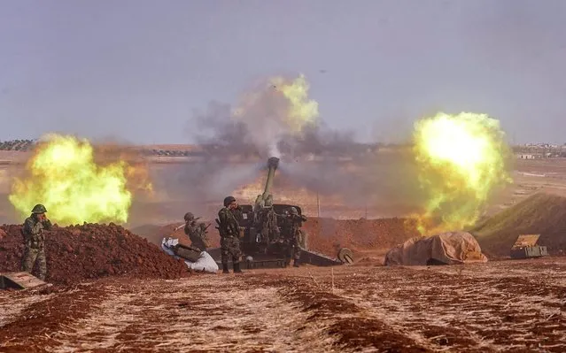 A handout picture released by the official Syrian Arab News Agency (SANA) on October 22, 2019 shows Syrian army artillery guns firing from a position in al-Habit on the southern edges of the Idlib province. (Photo by SANA/AFP Photo)
