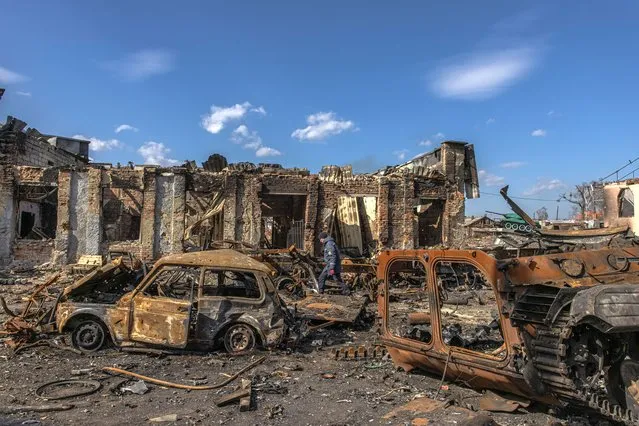 A Ukrainian rescue worker walks past destroyed Russian military vehicles as he looks for explosive items next to the railway station where the Russian forces were stationed, in the recaptured by the Ukrainian army Trostyanets town, in Sumy region, Ukraine, 29 March 2022 (issued 30 March 2022). Trostyanets was recaptured by the Ukrainian army after the town was under Russian forces from the first days of the war for over a month. Russian troops entered Ukraine on 24 February prompting the country's president to declare martial law and triggering a series of announcements by Western countries to impose severe economic sanctions on Russia. (Photo by Roman Pilipey/EPA/EFE)