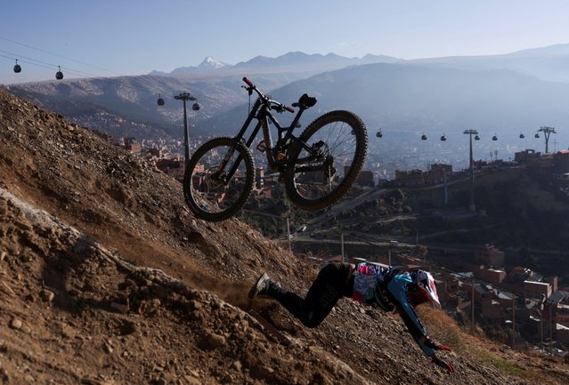 A cyclist falls during his practice ahead of the Challenge Downhill mountain biking race, in La Paz, Bolivia on June 30, 2024. (Photo by Ricardo Moraes/Reuters)