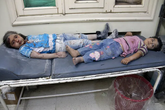 Injured Syrian children rest on a bed as they wait for treatment following a reported shelling on the Hamra neighbourhood of the northern Syrian city of Aleppo on May 21, 2014. (Photo by Zein Al-Rifai/AFP Photo)