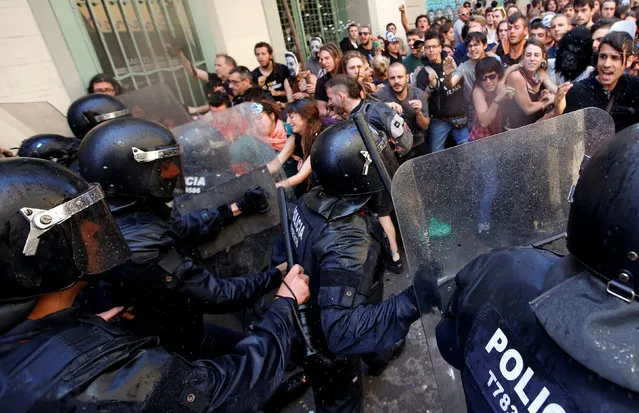 Catalan regional police in full riot gear charge at demonstrators during a protest over the eviction of squatters earlier in the week from “The Expropriated Bank”, in Barcelona, Spain, May 29, 2016. (Photo by Albert Gea/Reuters)