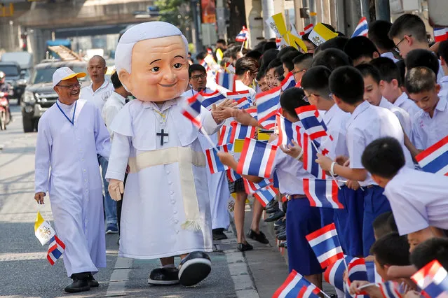 A Thai man dressed in a Pope Francis costume greets young students waving Thai and Vatican flags Pope Francis' arrival to the Apostolic Nunciature Embassy of the Holy See in Bangkok, Thailand, 20 November 2019. Pope Francis has begun his three-day visit to Thailand, which runs from 20 to 23 November 2019. It will mark the 350th anniversary of the founding of the “Mission de Siam” and is aimed at promoting inter-religious dialogue. Francis is the first pontiff to visit Thailand in nearly four decades. It will be the second papal to visit Thailand after the late John Paul II in 1984. (Photo by Diego Azubel/EPA/EFE)