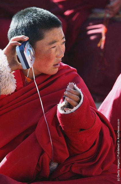 A nun listens to the lecture of a master with a portable stereo at the Serthar Wuming Buddhist Study Institute