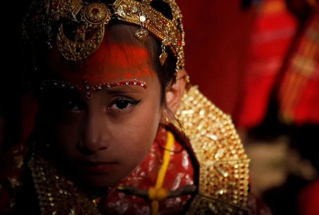 Light illuminates a Newari girl as she takes part at the Ihi ceremony in Bhaktapur, Nepal on December 6, 2019. The two-day ceremony begins with purification rituals and ends with “Kanyadan” (giving away the virgin) of the girl by her father. A Newari girl gets married thrice in her life, first with Bel, the fruit of a wood-apple tree, secondly with the sun, and lastly with her future husband. (Photo by Monika Deupala/Reuters)