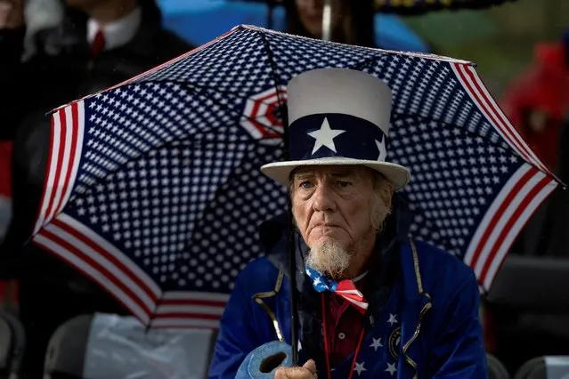 A man holding an umbrella waits for former U.S. President Donald Trump to speak during a rally to boost Pennsylvania Republican U.S. Senate candidate Dr. Mehmet Oz ahead of the May 17 primary election at the Westmoreland Fairgrounds in Greensburg, Pennsylvania, U.S. May 6, 2022. (Photo by Hannah Beier/Reuters)