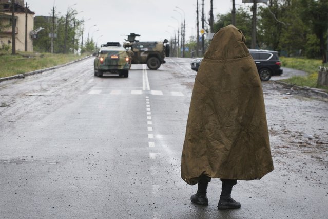 A serviceman of Donetsk People's Republic militia stands guard not far from the besieged Mariupol's Azovstal steel plant in Mariupol, in territory under the government of the Donetsk People's Republic, eastern Ukraine, Wednesday, May 18, 2022. (Photo by AP Photo/Stringer)
