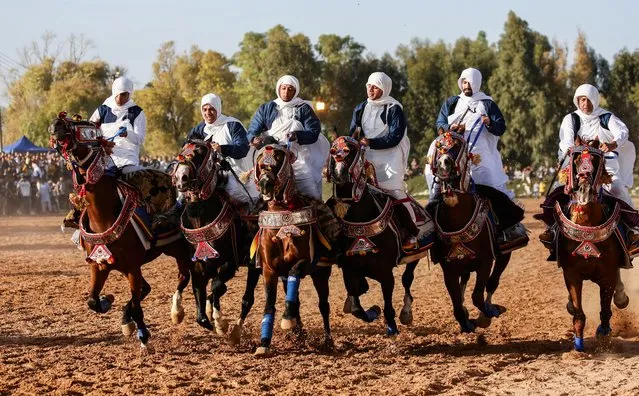 Men wearing traditional costumes ride horses during a horse race in Misrata, Libya on May 24, 2022. (Photo by Ahmed Hazem/Reuters)