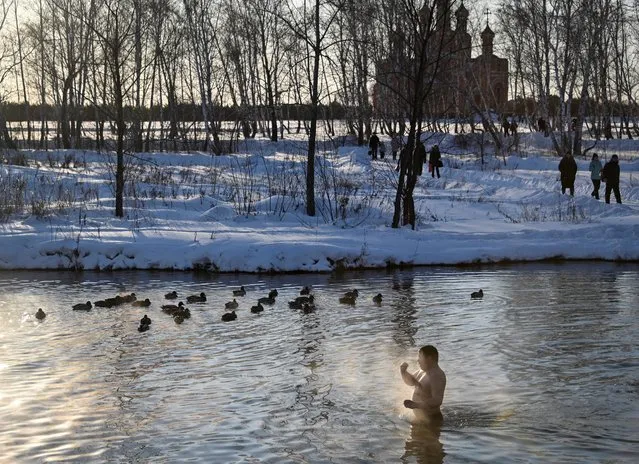A man crosses himself as he takes a dip during celebrations of the Orthodox Christian feast of Epiphany in Omsk, Russia on January 19, 2020. (Photo by Alexey Malgavko/Reuters)