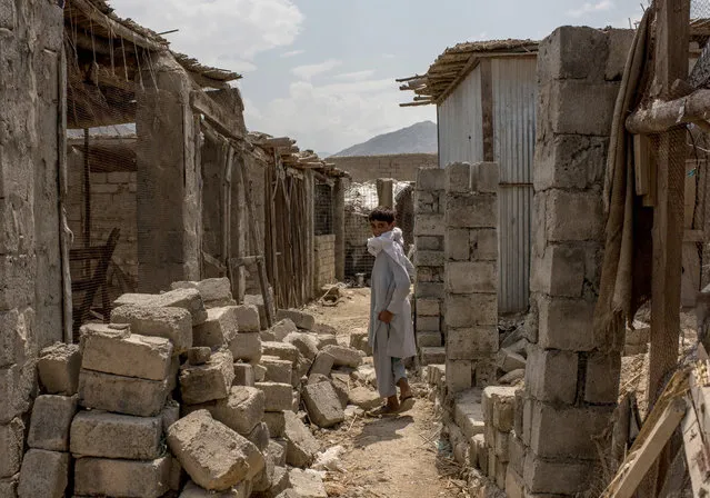 A boy walks through buildings damaged from fighting on July 15, 2017 in Shadal Bazaar, Afghanistan. (Photo by Andrew Renneisen/Getty Images)