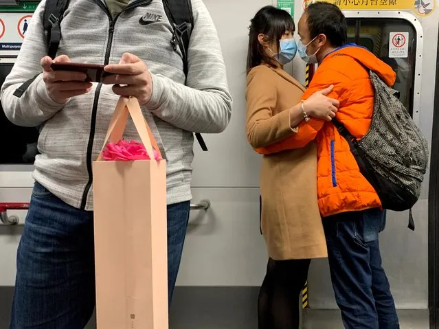 A couple wearing masks embrace in an MTR train, following the outbreak of the novel coronavirus on Valentine's Day in Hong Kong, China on February 14, 2020. (Photo by Tyrone Siu/Reuters)