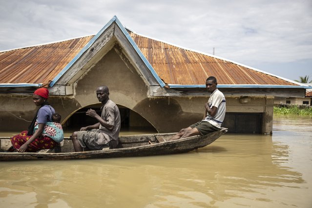 Residents sit in a pirogue as they move between submerged houses in the flooded area of Adankolo  in Lokoja on October 21, 2024. (Photo by Olympia de Maismont/AFP Photo)