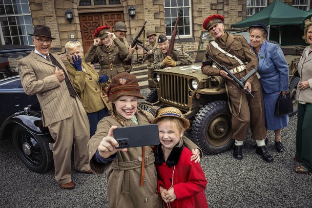 Historical re-enactment enthusiasts, including Tabitha and Penelope Airey, nine and five, pose for a selfie ahead of the Way Back When: 1940s Weekend held at Ushaw Historic House, County Durham, UK on August 4, 2023. (Photo by James Glossop/The Times)