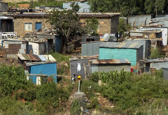 In this photograph taken Thursday March 19, 2020 , A woman spills water at squatter camp in Soweto, South Africa. Some countries around the world lack the equipment and trained health workers to respond to the threat of COVID-19 virus. (Photo by Themba Hadebe/AP Photo)