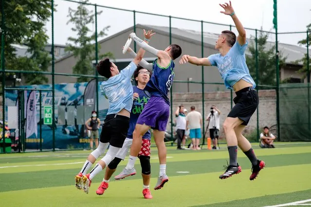 Players snatch for a frisbee during a match of the first Frisbee pre-season CUDL (Chinese Ultimate Disc League) on a football field in Beijing, China, 09 July, 2022. (Photo by Wu Hao/EPA/EFE)