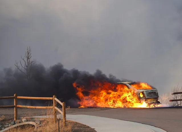 A car burns as a wind-driven wildfire forced evacuation of the Superior suburb of Boulder, Colorado, December 30, 2021. Hundreds of homes are feared lost in fast-moving wildfires in the US state of Colorado, officials said Thursday, as flames tear through areas desiccated by a historic drought At least 1,600 acres have burned in Boulder County, much of it suburban, with warnings that deaths and injuries were likely as the blaze engulfes hotels and shopping centers Extreme winds topping 100 mph caused grass fires to quickly spread into the Colorado towns of Superior and Louisville resulting in the mandatory evacuation of over 30,000 residents. (Photo by Trevor Hughes/USA Today Network via Reuters)