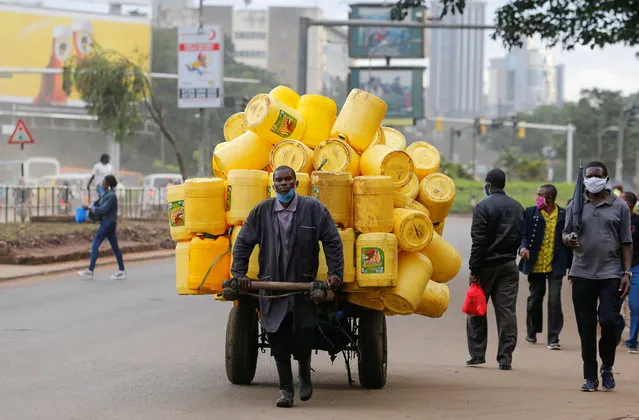 A man pulls a handcart with jerrycans along the street before a curfew, as the spread of the coronavirus disease (COVID-19) continues, in downtown Nairobi, Kenya on April 23, 2020. (Photo by Thomas Mukoya/Reuters)