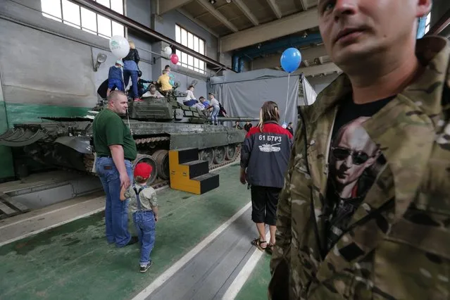 People visit the 61st Armored Vehicle repair plant during the Open Day as they celebrate 75 years of the plant in Strelna, outside St. Petersburg, Russia, 05 August 2016. (Photo by Anatoly Maltsev/EPA)