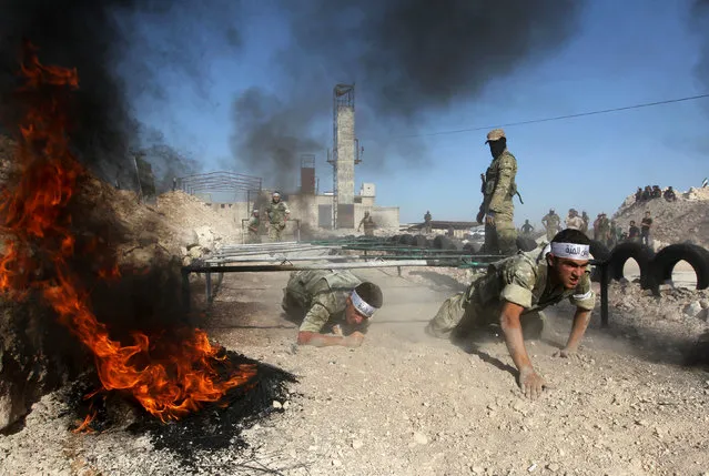 Fighters from Jaish al-Izzah, part of the Free Syrian Army, demonstrate their skills during a military display as part of a graduation ceremony at a camp in the Hama province, Syria July 29, 2016. (Photo by Ammar Abdullah/Reuters)