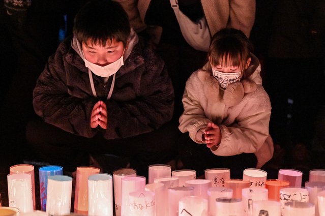 Children pray during an early morning ceremony to remember the victims on the 30th anniversary of the “Great Hanshin Earthquake” in the city of Kobe, Hyogo Prefecture, on January 17, 2025. The port city of Kobe was hit by a massive quake on January 17, 1995, killing 6,434 people and levelling much of the city. (Photo by Richard A. Brooks/AFP Photo)