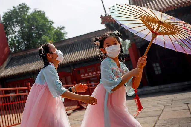 Children wearing protective face masks play near the entrance to the Forbidden City on the day of the opening of the National People's Congress (NPC) following the outbreak of the coronavirus disease (COVID-19), in Beijing, China on May 22, 2020. (Photo by Thomas Peter/Reuters)