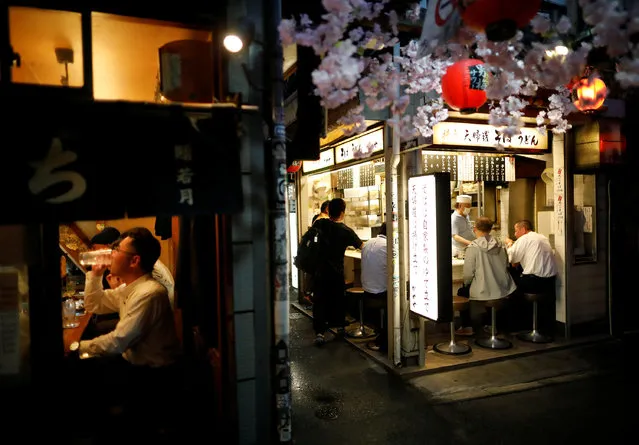 People enjoy drinks and dinner following the coronavirus disease (COVID-19) outbreak, at the partially reopened Japanese drinking bars alley, on the first day after the Japanese government lifted the state of emergency at Shinjuku district in Tokyo, Japan on May 26, 2020. (Photo by Issei Kato/Reuters)