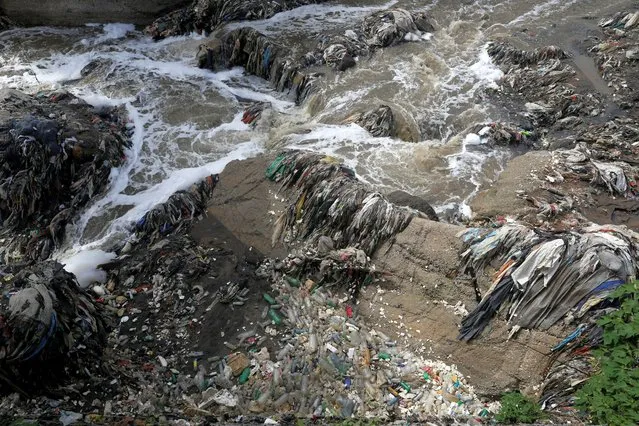 Garbage and plastic bottles float on Las Vacas river considered one of the most polluted rivers in the world, in the municipality of Chinautla, where the Ocean Cleanup NGO is testing a device to contain the garbage that ends up in the Atlantic Ocean, in Guatemala City, Guatemala on June 8, 2022. (Photo by Luis Echeverria/Reuters)