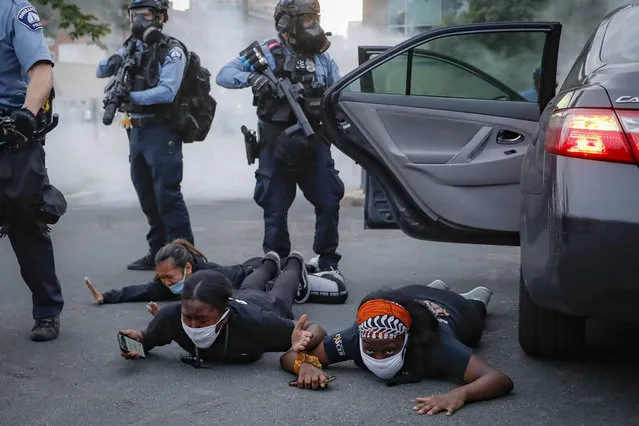 Motorists are ordered to the ground from their vehicle by police during a protest on South Washington Street, Sunday, May 31, 2020, in Minneapolis. Protests continued following the death of George Floyd, who died after being restrained by Minneapolis police officers on Memorial Day. (Photo by John Minchillo/AP Photo)