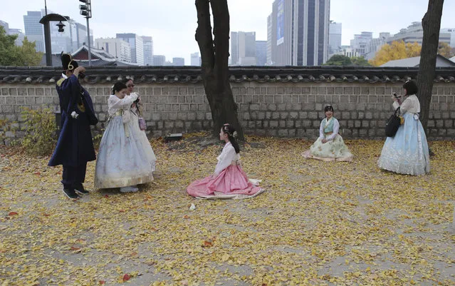 Visitors dressed in South Korean traditional “Hanbok” attire take their souvenir photos at the Gyeongbok Palace, the main royal palace during the Joseon Dynasty, and one of South Korea's well known landmarks, in Seoul, South Korea, Friday, November 10, 2017. (Photo by Lee Jin-man/AP Photo)