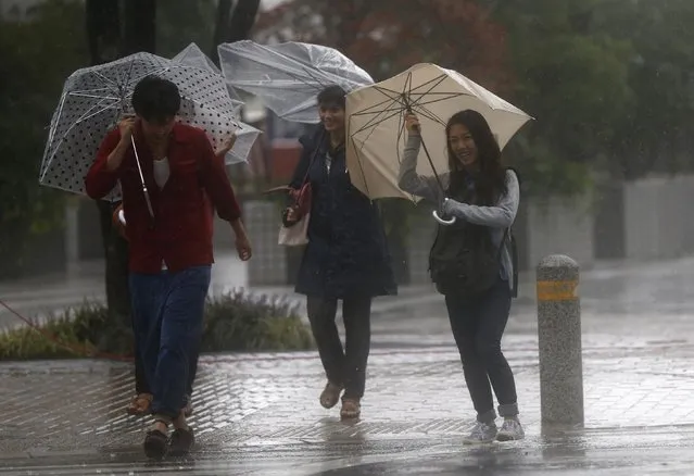 Passers-by with umbrellas struggle against strong winds and heavy rain caused by Typhoon Phanfone, in Tokyo October 6, 2014. (Photo by Issei Kato/Reuters)