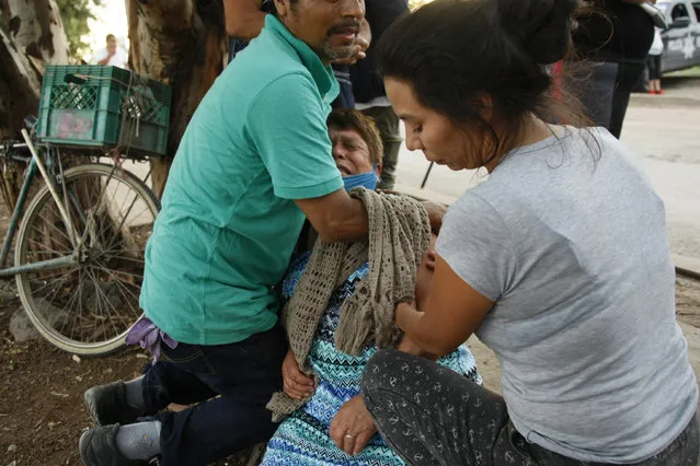 Relatives comfort a woman crying outside an unregistered drug rehabilitation center in Irapuato, Mexico, Wednesday, July 1, 2020, after gunmen burst into the facility and opened fire. According to police at least 24 people were killed in the attack. (Photo by Mario Armas/AP Photo)
