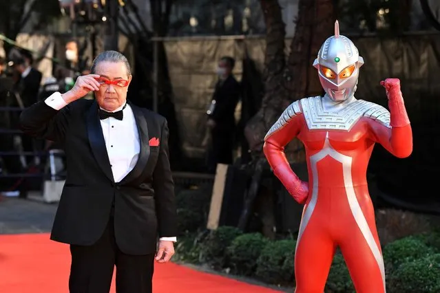 Japanese cast member Kohji Moritsugu (L) and the character Ultraseven, from the special 55th anniverary screening screening of the science fiction classic “Ultraseven”, pose upon their arrival at the opening ceremony of the 35th Tokyo International Film Festival in Tokyo on October 24, 2022. (Photo by Kazuhiro Nogi/AFP Photo)