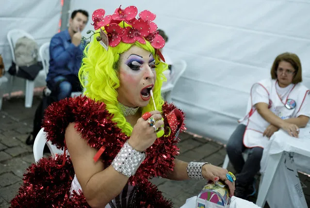 A drag queen collects oral fluid from her gums for an HIV test, during an HIV/AIDS awareness campaign, on the occasion of World AIDS Day in Sao Paulo, Brazil December 1, 2017. (Photo by Nacho Doce/Reuters)