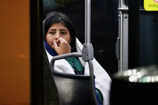 After being transported by bus from the U.S. border in Texas, migrant woman sits in a bus provided by city officials, in Philadelphia, Pennsylvania, U.S., November 16, 2022. (Photo by Bastiaan Slabbers/Reuters)