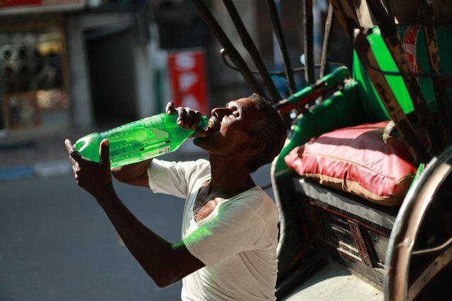 An Indian hand rickshaw puller drinks water during a hot afternoon in Kolkata, India, 27 March 2025. According to the weather department, the maximum temperature could reach 39 degrees Celsius, as the summer or pre-monsoon season lasts from March to July. (Photo by Piyal Adhikary/EPA/EFE)