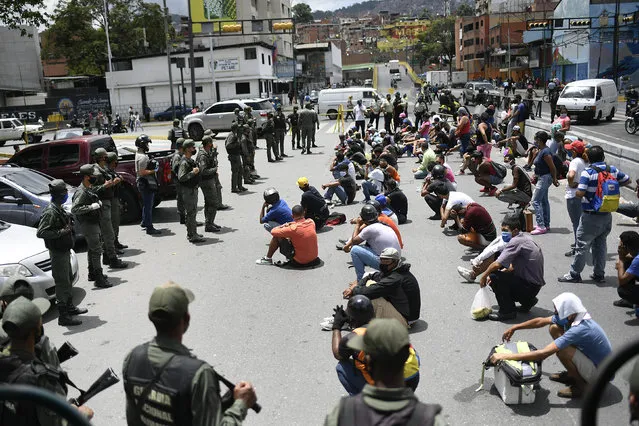 Members of the Bolivarian National Guarde explain proper mask use to non-compliant pedestrians and peddlers on a street of the Petare neighborhood of Caracas, Venezuela, Wednesday, July 29, 2020, amid efforts to contain the spread of the new coronavirus. (Photo by Matias Delacroix/AP Photo)