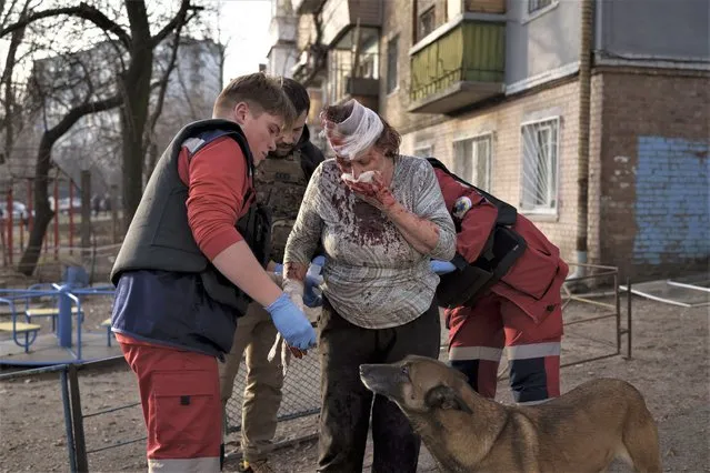 Emergency workers help a woman injured after a Russian attack in Kyiv, Ukraine, Saturday, December 31, 2022. (Photo by Roman Hrytsyna/AP Photo)