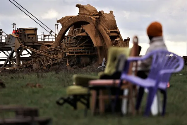 An environmental activist sits near a mine as police officers prepare for the planned evacuation of Luetzerath, a village that is about to be demolished to allow for the expansion of the Garzweiler open-cast lignite mine of Germany's utility RWE, Germany on January 3, 2023. (Photo by Thilo Schmuelgen/Reuters)