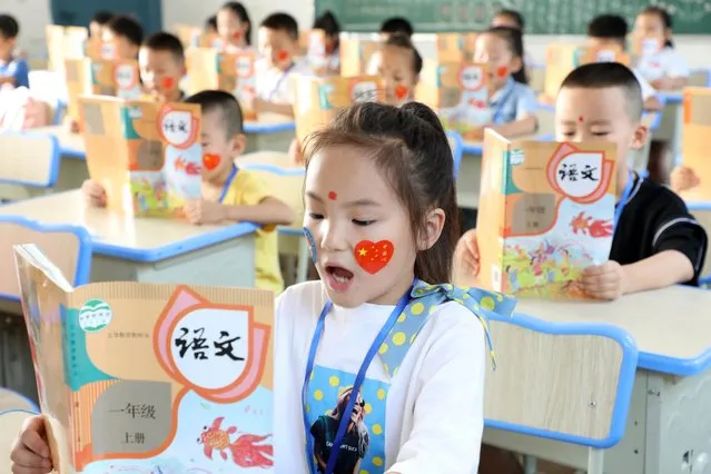 First graders read the lesson on the first day of a new semester on August 31, 2020 in Jiujiang, Jiangxi Province of China. (Photo by Hu Guolin/VCG via Getty Images)