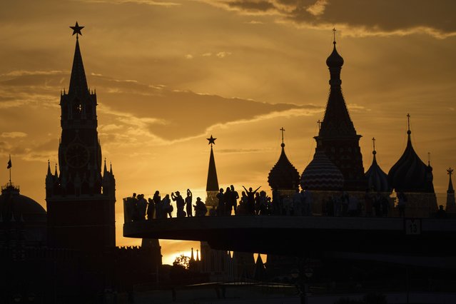 People watch and photograph sunset behind the Kremlin standing on the “Flying glass bridge” over the Moscow River at Zaryadye park in Moscow, Russia, Thursday, May 29, 2025. (Photo by Alexander Zemlianichenko/AP Photo)