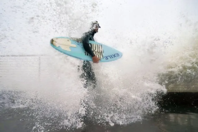 Thomas Heins is hit by a wave while standing at the seawall in Pacifica, Calif., Thursday, January 5, 2023. Damaging winds and heavy rains from a powerful “atmospheric river” pounded California on Thursday. (Photo by Godofredo A. Vásquez/AP Photo)