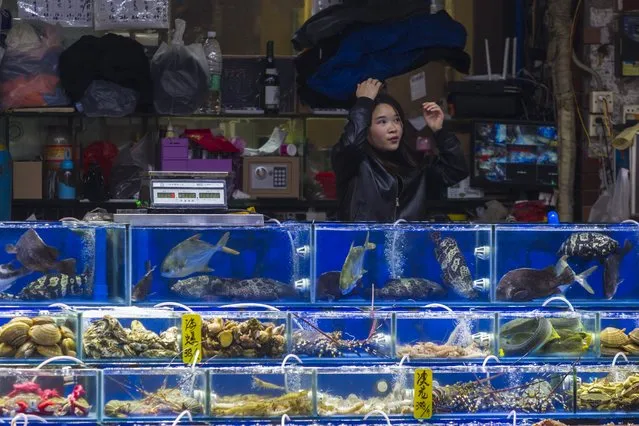 Vendor sells seafood to costumers on Huangsha Seafood Market in Guangzhou, Guandong Province, China, 20 January 2018. (Photo by Aleksandar Plavevski/EPA/EFE)