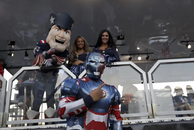 Tony Thornton, of Galveston, Texas, wears his “The Iron Texan” outfit while posing with New England Patriots mascot Pat Patriot and Patriots cheerleaders at the NFL Thursday Night Football set in the parking lot of Gillette Stadium before an NFL football game between the Patriots and the Houston Texans Thursday, September 22, 2016, in Foxborough, Mass. (Photo by Charles Krupa/AP Photo)