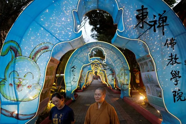 People walk through the Chinese Lunar New Year decorations at Fo Guang Shan Dong Zen Buddhist Temple in Jenjarom, Selangor, Malaysia on January 13, 2023. (Photo by Hasnoor Hussain/Reuters)