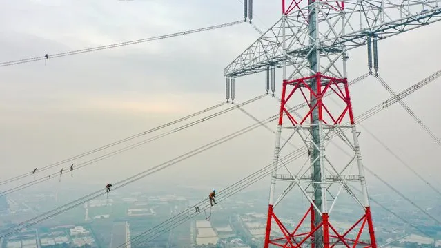 Aerial photo shows workers checking the wires of the world's highest transmission tower in Wuxi City, east China's Jiangsu Province on February 20, 2023. (Photo by Rex Features/Shutterstock)