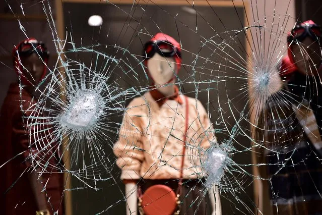 A damaged window of a store is seen as people protest against the new restrictions introduced by the government to curb the coronavirus, in Turin, Italy, October 26, 2020. (Photo by Massimo Pinca/Reuters)